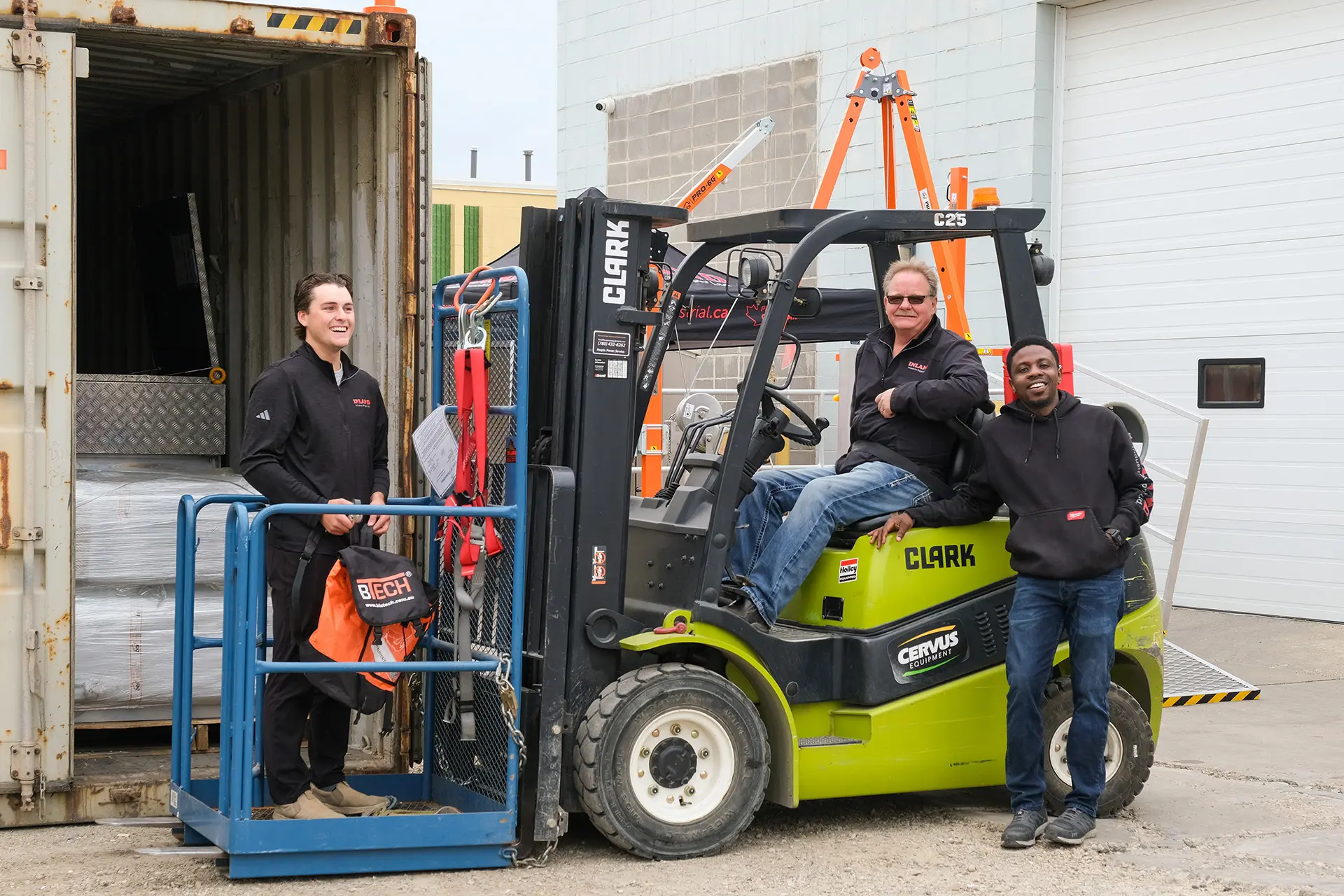 employees working and posing for a picture on a fork lift